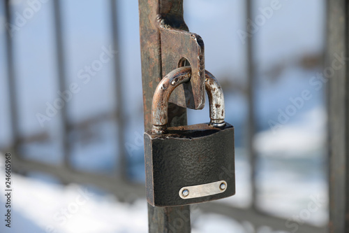 Old padlock in the snow, hanging on