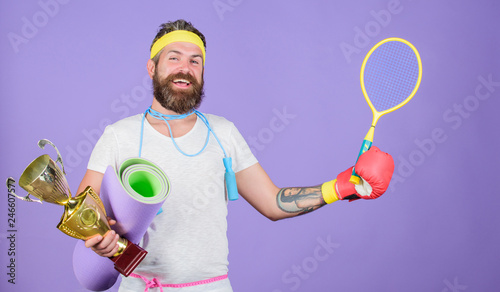 Get body ready for summer. Choose sport you like. Man bearded athlete hold sport equipment jump rope fitness mat boxing glove expander racket and golden goblet. Sport shop assortment. Sport concept © be free
