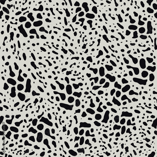 Black animal skin leopard pattern on light background. Seamless background with random black elements. Abstract ornament.