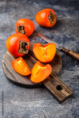 Quadro su tela Ripe persimmon fruit on dark