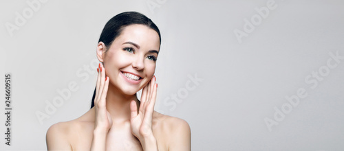 Portrait of young beautiful smiling woman with healthy glow perfect smooth skin. Model with natural nude make up. Skincare, wellness, beauty clinic, facial treatment, cosmetology concept.
