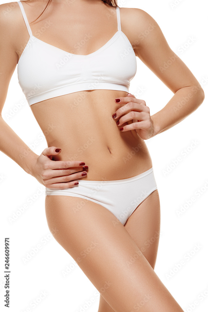 Perfect slim toned young body of the girl or fit woman at studio. The fitness, diet, sports, plastic surgery and aesthetic cosmetology concept. Image is not body shape retouched