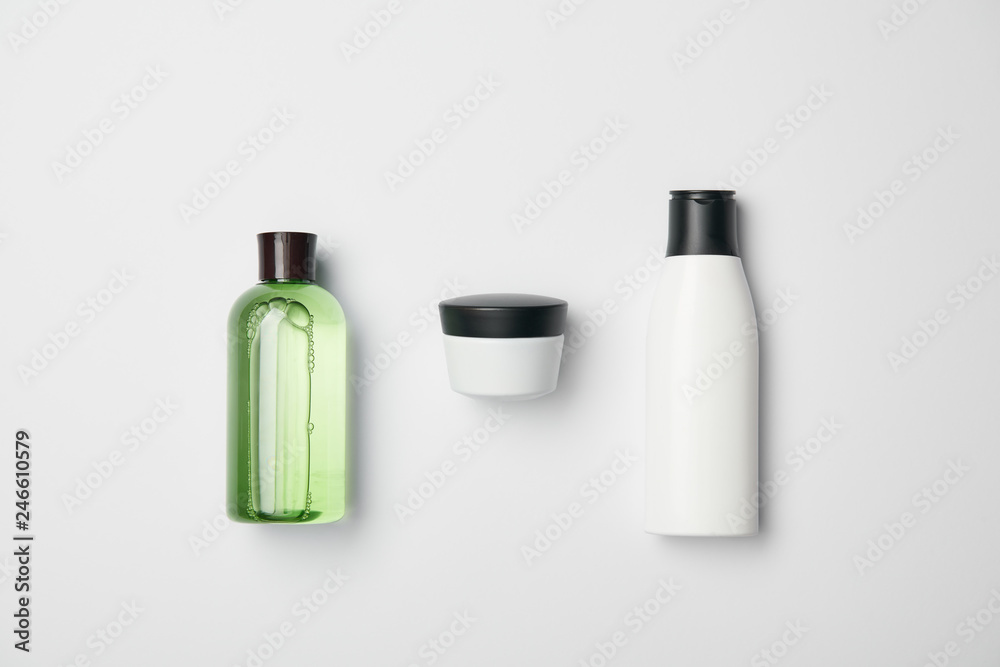 Top view of different cosmetic bottles on white background Top view of different cosmetic bottles on white background
