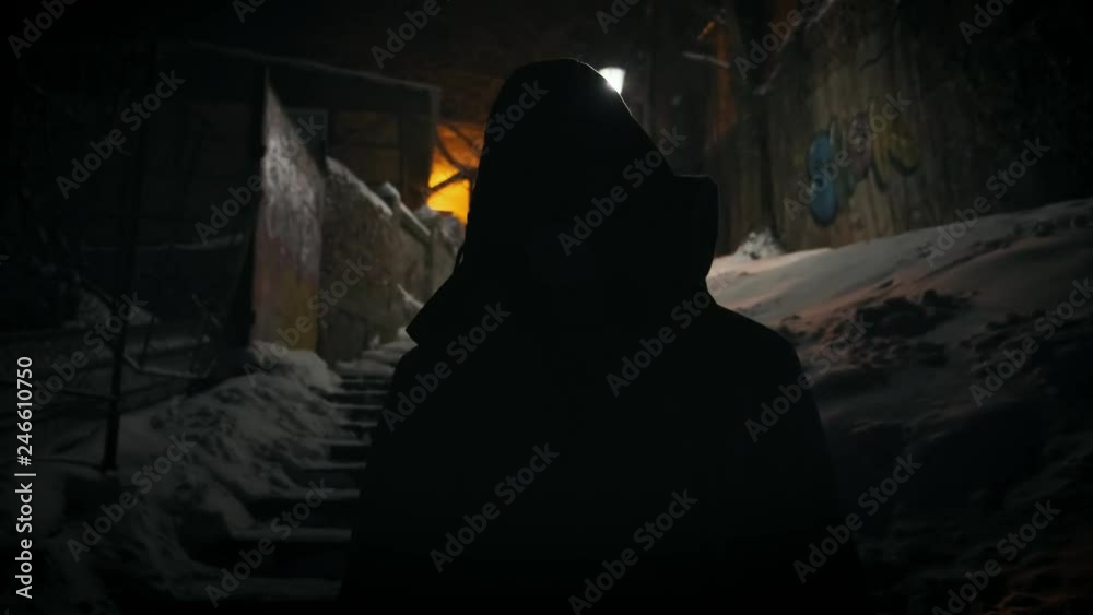 Man in gas mask standing near broken street lamp Turning to the camera. Natural strobe light. Horror scene