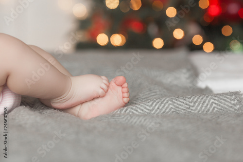 Baby`s feet on the bed. Background with unrecognizable child`s little fingers. An infant toes with free space