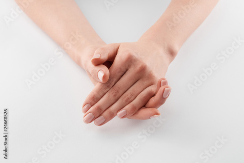 Partial view of female clanched hands on white background