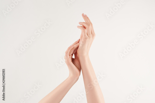 Partial view of woman applying cosmetic cream on white background