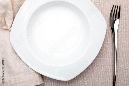 Empty white plate. On delicate beige tablecloth. Concept to include your food and your text.