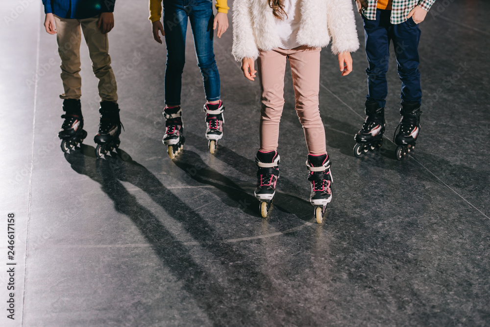 Cropped view of children in roller skates standing in roller rink Cropped view of children in roller skates standing in roller rink