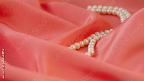 Beautiful background, on fabric color living coral are pearl beads