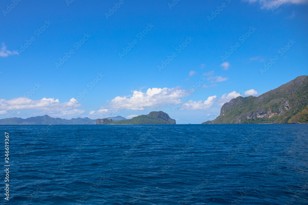Blue sea and sky landscape with distant island. Palawan island hopping seascape. Philippines travel photo