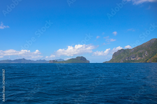 Blue sea and sky landscape with distant island. Palawan island hopping seascape. Philippines travel photo