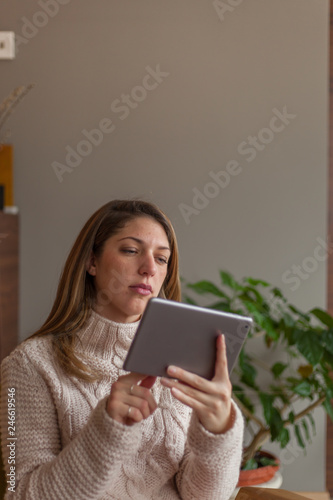 Portrait of a young woman using digital tablet indoors