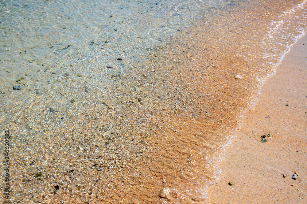 Turquoise sea water on sandy beach. Sea tide on sand. Tropical seaside photo. Marine holiday. Seashore landscape