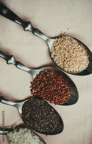 Superfoods and small bowls on white wooden table Chia goji hemp seeds quinoa linen sesame Copy space Top view or flat lay Vertical