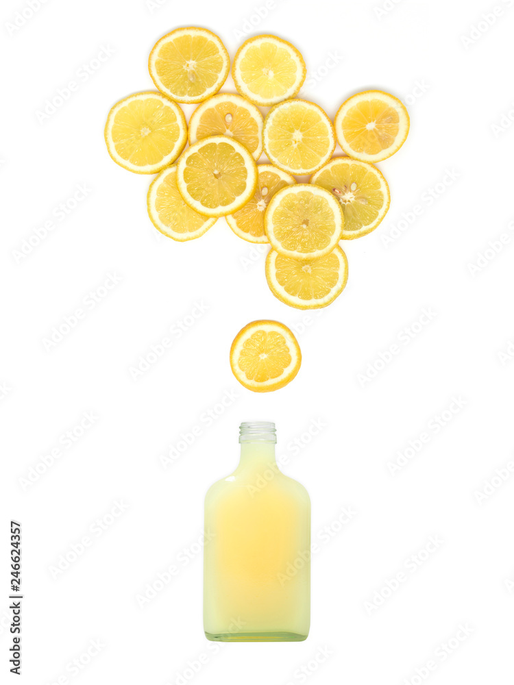 bottle with fresh lemon juice is standing under many lemon slices on white background bottle with fresh lemon juice is standing under many lemon slices on white background