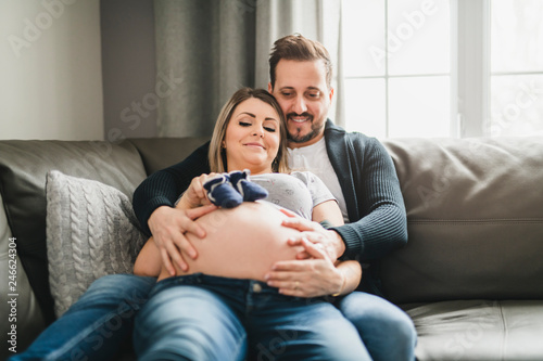 A Couple With Pregnant Woman Relaxing On Sofa Together
