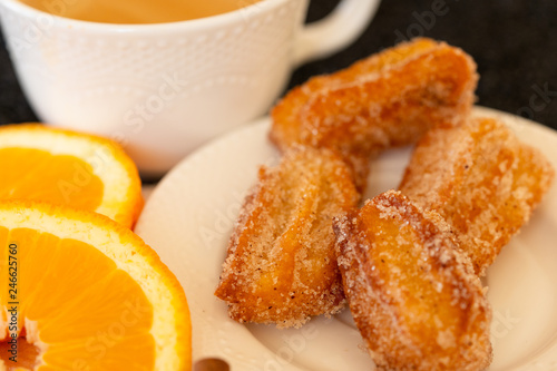 Spanish cuisine: churos and orange close-up on the table