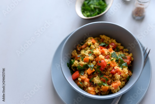 Healthy vegan bowl with quinoa, pumpkin, pepper and carrot on gray wooden background. Selective focus