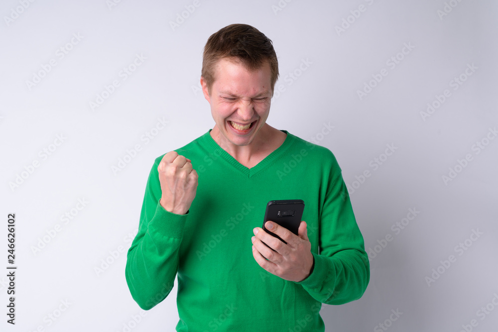 Happy young handsome man using phone and getting good news Happy young handsome man using phone and getting good news