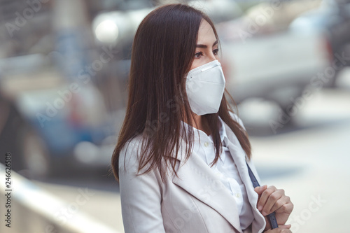 Asian woman are going to work.she wears N95 mask.prevent PM2.5 dust and smog