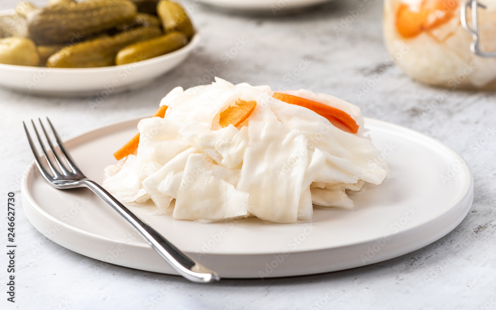 Fermented cabbage on a white plate close-up.