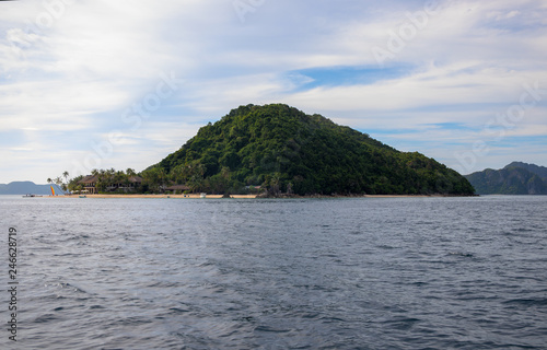 Tropical island in still sea. Palawan island seascape. Philippines travel photo. Beautiful green island with sandy beach