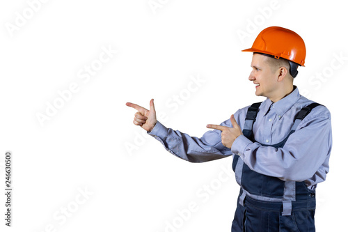 A civil engineer in an orange helmet looks to the side and points at something. isolated