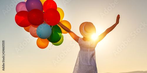 happy woman with balloons at sunset in summer