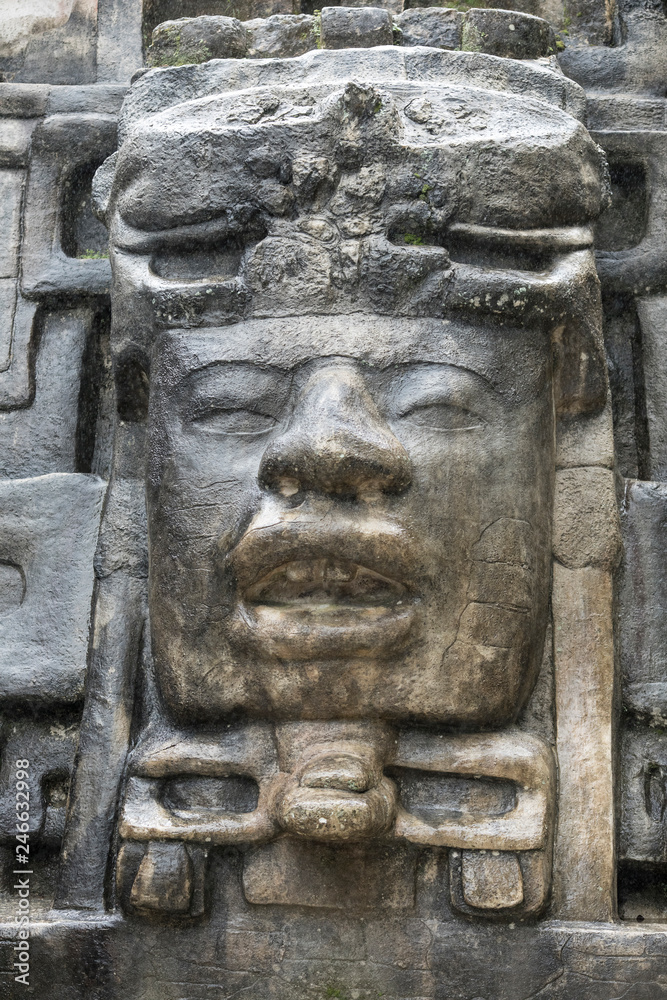Close up shot of the Olmec style stone mask on the Mayan temple of Lamanai in Belize.