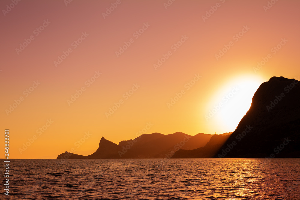 mountains in the sea at sunset