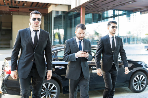 Young Bodyguards Walking By Businessman photo