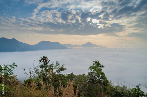 sunrise at Phu Thok, beautiful mountain view misty morning of top mountain around with sea of mist moving up to the sky with cloudy sky background, Chiang Khan District, Loei, Thailand.