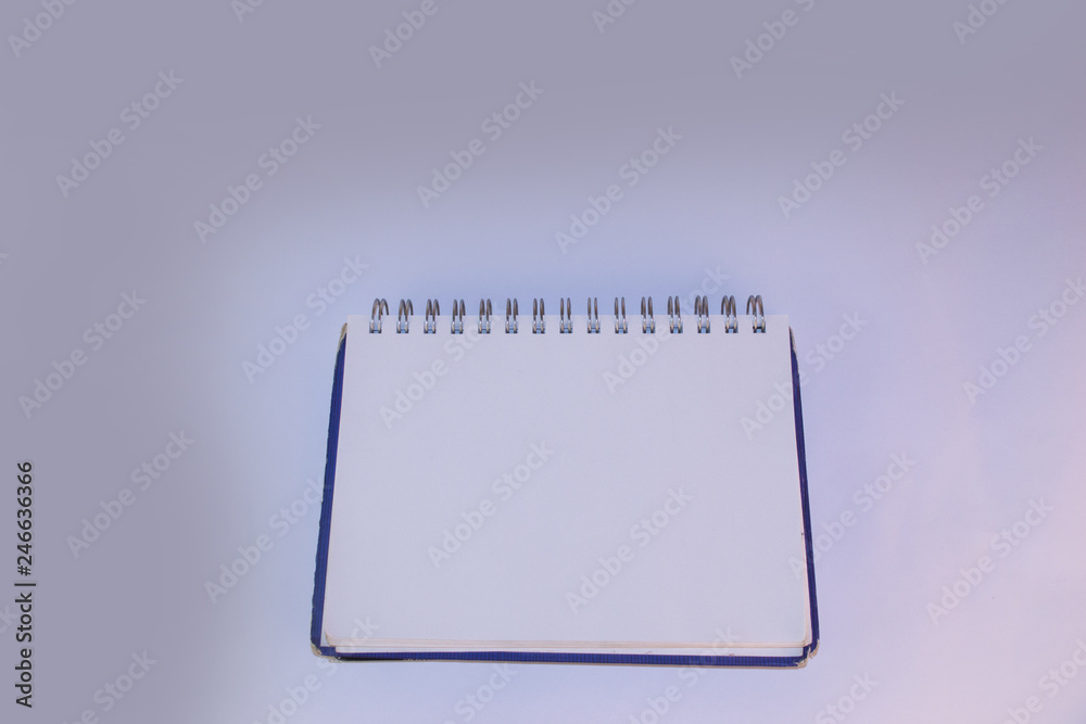 Notebook with blue cover and white sheets lies on a white background Notebook with blue cover and white sheets lies on a white background