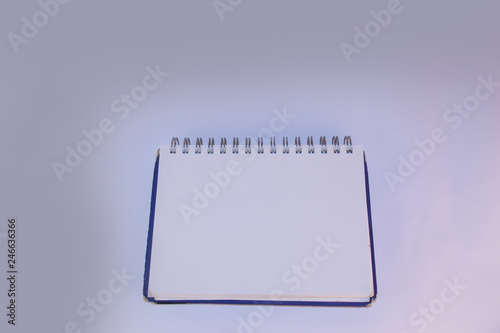 Notebook with blue cover and white sheets lies on a white background