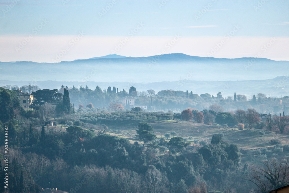 Panorama of Tuscany mountains in morning winter fog, San Gimignano, Italy