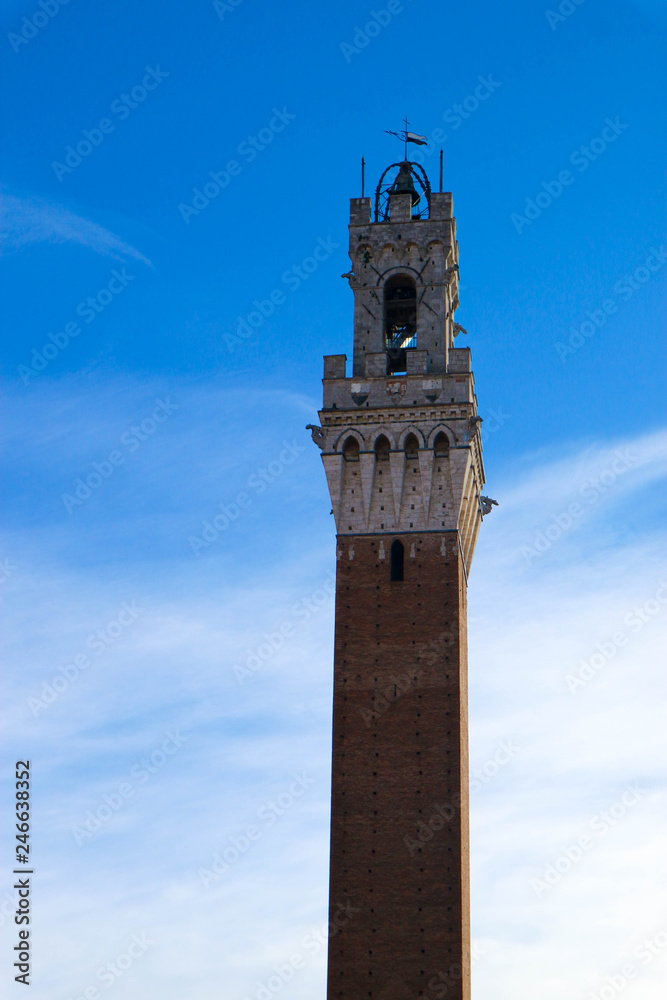 Symbol of Siena, tower Torre del Mangia on blue sky background, Tuscany, Italy