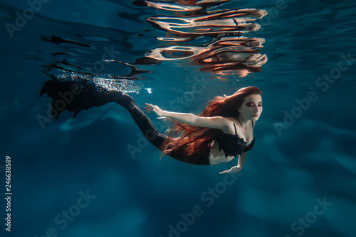 Underwater red hair freediver girl with mermaid tale