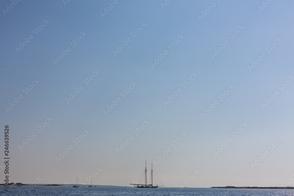 Sail boat in open sea on the horizon. Copyspace