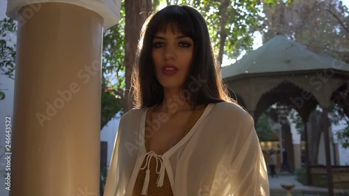 Beautiful Moroccan Girl Waving her white mantle in Picturesque Dar Si Said Riyad in Marrakech at sunset time photo