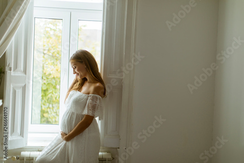 Young pregnant woman standi...