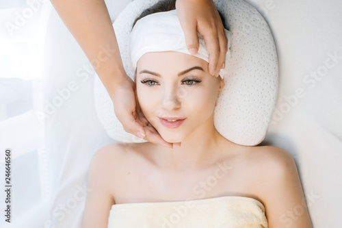 Female with healthy glow perfect smooth skin. Cosmetology, beauty and spa concept. Face massage. Young woman getting spa treatment. Beautiful girl enjoying face massage at beauty salon.
