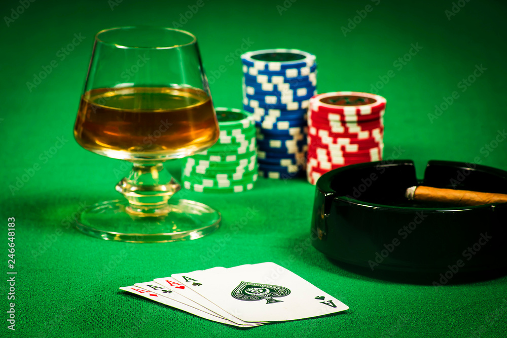 The concept of gambling, cards and chips with a glass of cognac and a cigar