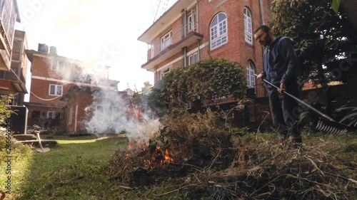 Time-lapse of man burning green waste in his garden photo