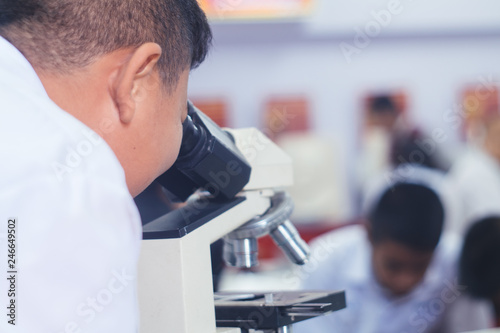 Students looking microscope in science class