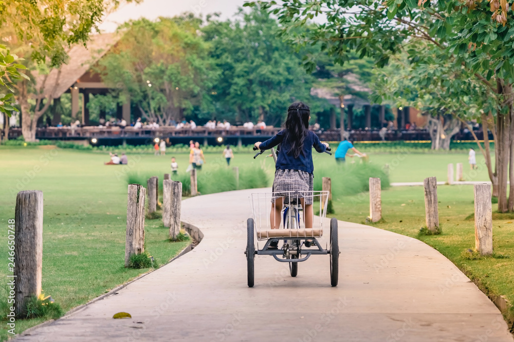 People exercising by cycling in the evening at the public park. People exercising by cycling in the evening at the public park.