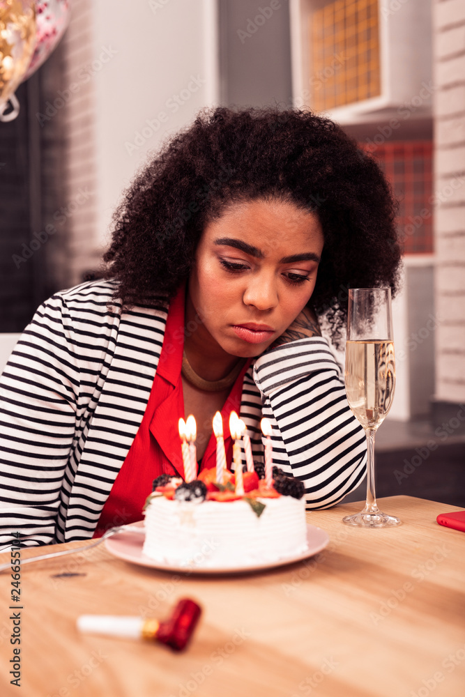 Cheerless unhappy woman having a sad birthday celebration Cheerless unhappy woman having a sad birthday celebration