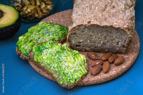 Healthy avocado toasts for breakfast or lunch with rye bread, sliced avocado, arugula, pumpkin and sesame seeds, salt and pepper. Vegetarian sandwiches. Plant-based diet. Whole food concept.