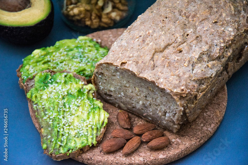 Healthy avocado toasts for breakfast or lunch with rye bread, sliced avocado, arugula, pumpkin and sesame seeds, salt and pepper. Vegetarian sandwiches. Plant-based diet. Whole food concept.