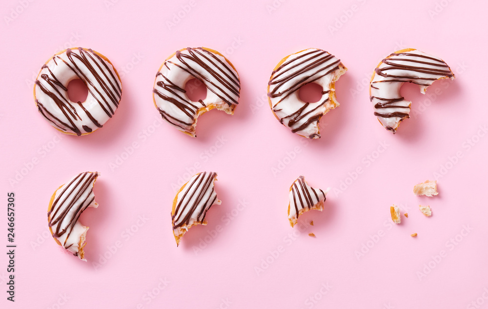 Donut eaten step by step. Stages of eating sweet glazed donut. Top view ...